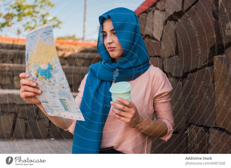 Arabische Frau navigiert mit Papierkarte lesen Landkarte navigieren Suche Anleitung Großstadt sich orientieren Kopftuch Hijab ethnisch arabisch muslimisch Fokus