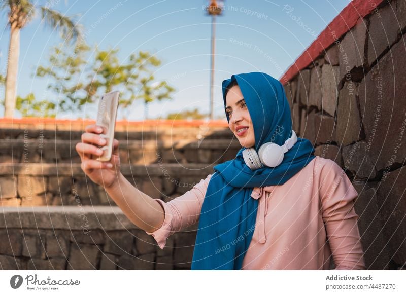 Arabische Frau im Hidschab macht Selfie in der Stadt Hijab Kopftuch Smartphone Selbstportrait Großstadt Moment charmant Tradition arabisch ethnisch muslimisch