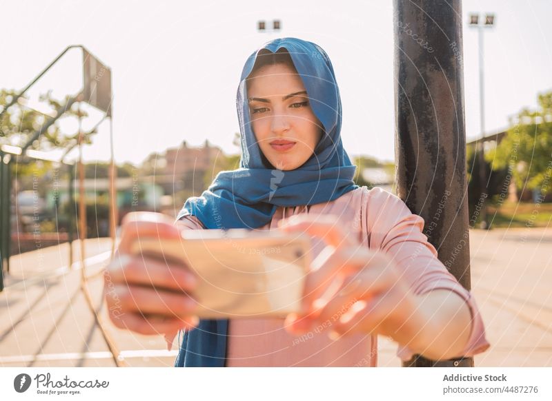 Arabische Frau im Hidschab macht Selfie in der Stadt Hijab Kopftuch Smartphone Selbstportrait Großstadt Moment charmant Tradition arabisch ethnisch muslimisch