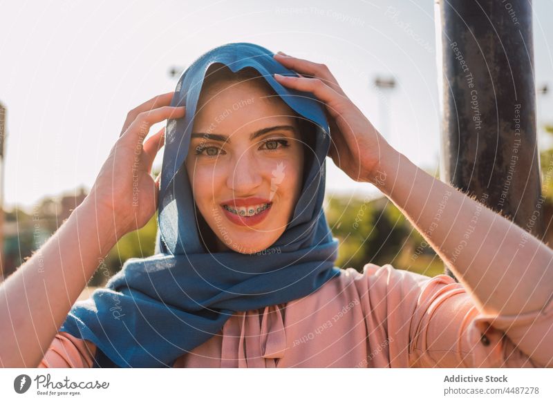 Charmante arabische Frau im Hidschab schaut in die Kamera Hijab Kopftuch Tradition Kopfschmuck Lächeln Zahnspange charmant heiter positiv ethnisch muslimisch