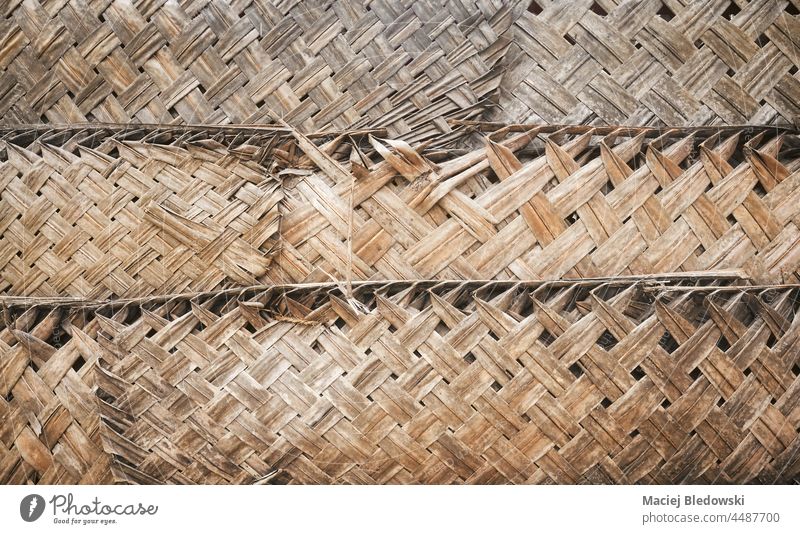 Getrocknetes Palmblattgeflecht an der Wand, natürlicher Hintergrund. Textur Blatt Handfläche Muster Tapete handgefertigt Geflecht organisch rustikal trocknen