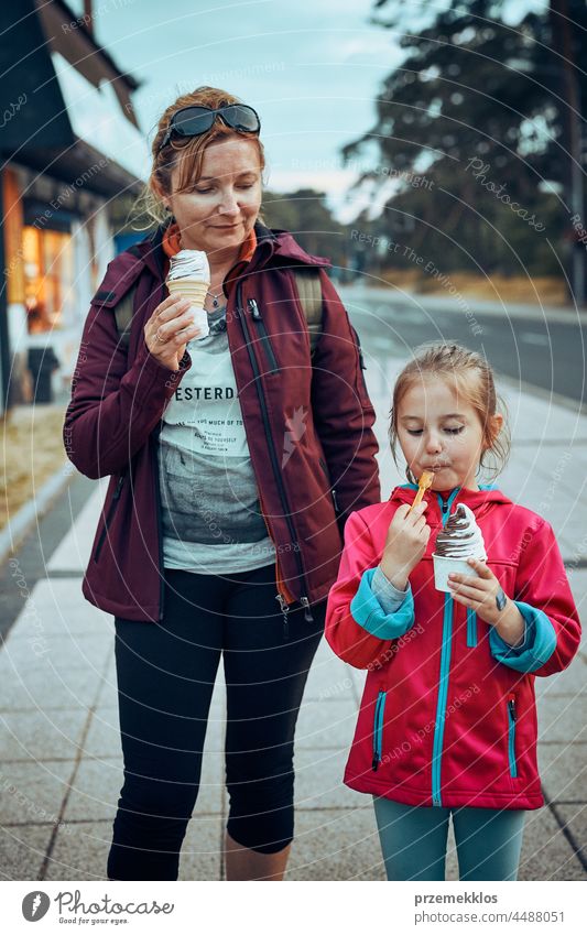 Mutter und ihre Tochter genießen ein Eis bei einem Spaziergang durch die Stadt am Nachmittag Speiseeis Familie Sommer süß Dessert Essen Person Kind Spaß Glück