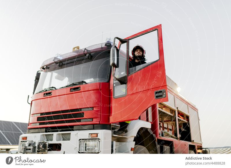 Feuerwehrmann steigt ins Feuerwehrauto Lastwagen Arbeit Notfall Beruf Gerät retten extrem Schutzhelm Mitarbeiter Uniform behüten Sicherheit Mut Held Risiko