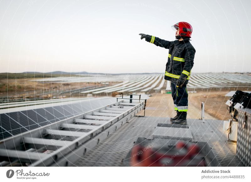 Feuerwehrmann steht auf dem Dach eines Lastwagens Mann Uniform Gerät professionell Bauernhof Sonnenkollektor Beruf Schutzhelm stehen männlich Motor Mut
