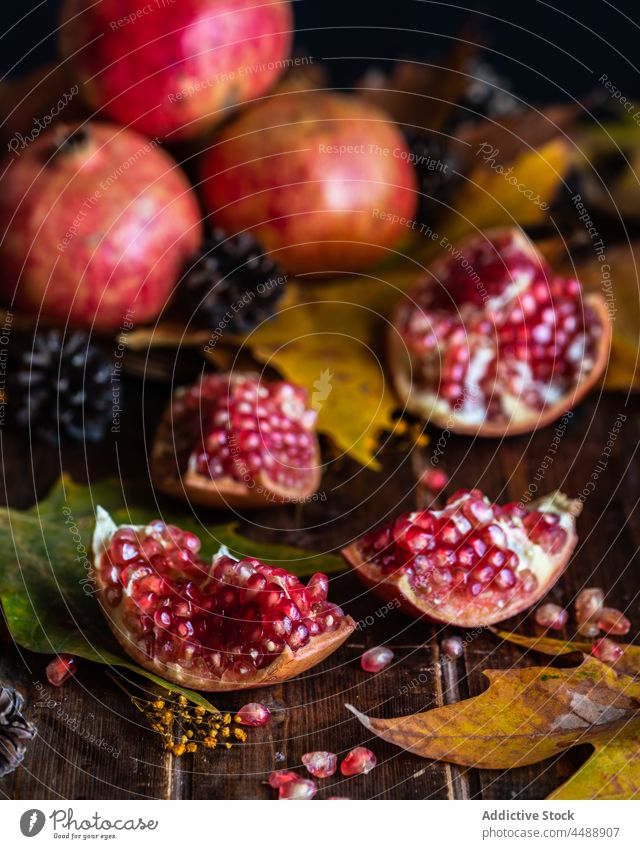 Stücke von reifen Granatäpfeln auf einem Holztisch Granatapfel Herbst Blatt rot süß Spielfigur Scheitel fallen natürlich Tisch hölzern frisch Saison Ernte