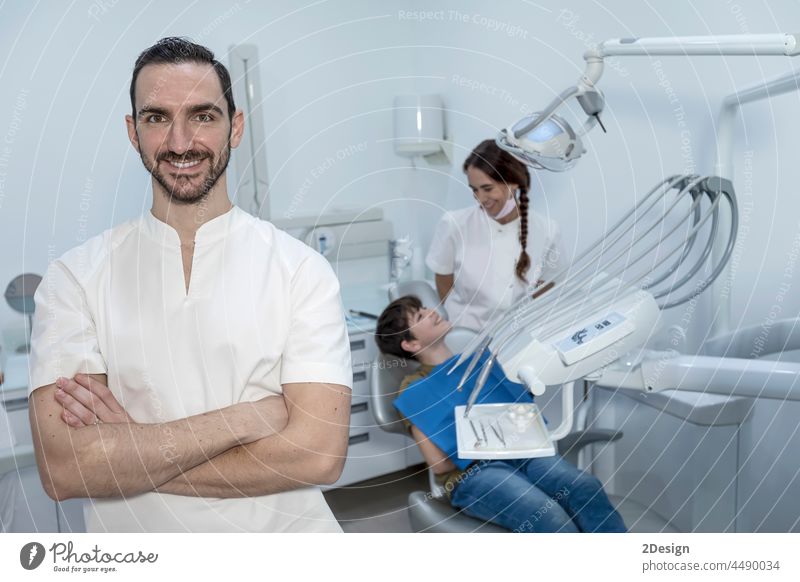 Ein Porträt eines Zahnarztes mit seinem Team im Hintergrund Konzentration Untersuchen geduldig Unterstützung Assistent Kompetenz Hygiene im Innenbereich Beruf