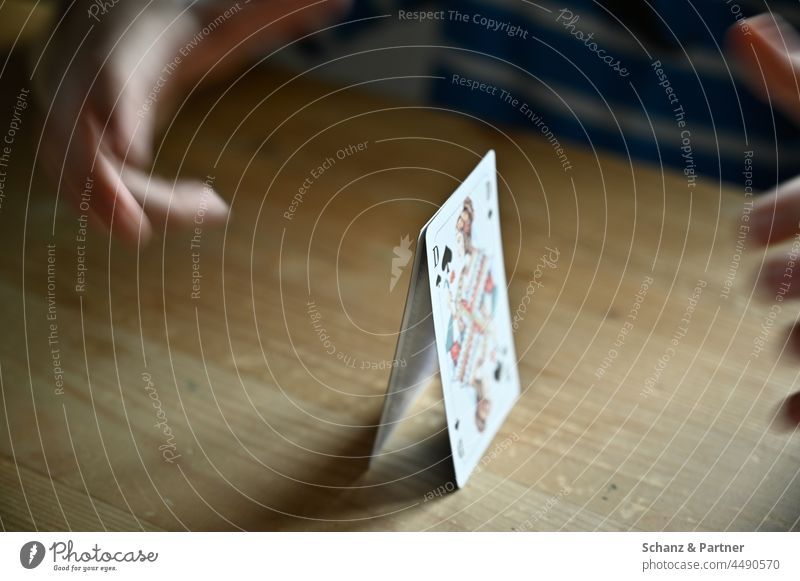 der Anfang eines Kartenhauses Spielkarten anfangen beginnen Fundament Grundstein Hände Tischplatte Dame Kartenspiel