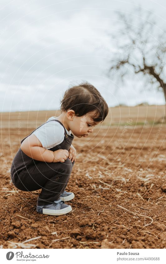 Kind beobachtet Ameisen auf dem Feld Kindheit 1-3 Jahre Kaukasier eine Person Seitenansicht Neugier erkunden Fröhlichkeit Leben Tag authentisch Farbfoto Freude