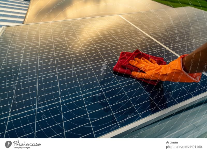 Mann reinigt Solarpanel auf dem Dach. Solarmodul oder Photovoltaik-Modul Wartung. Nachhaltige Ressource und erneuerbare Energie für grünes Konzept.  Solarenergie für grüne Energie. Technologie für die Zukunft.