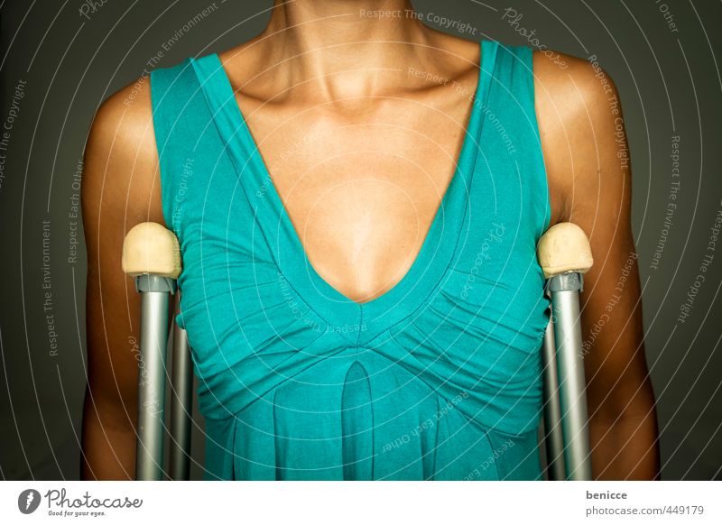Krücken Frau Mensch Unfall Gehhilfe Kleid grün blau Studioaufnahme Frauenbrust Oberkörper Fraktur Behinderte Patient Krankenhaus Versicherung Unfallgefahr