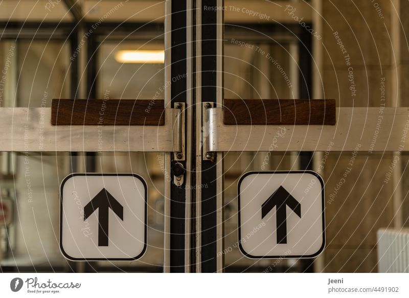 Eingangstür mit Pfeilen, welche die richtige Richtung anzeigen gerade geradeaus 2 zwei geradezu nach vorne drücken vorwärts Orientierung Zeichen Weg Wegweiser
