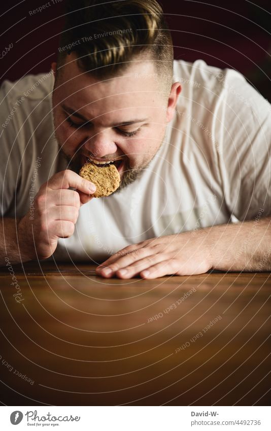 Mann beißt genüsslich in ein Plätzchen essen Keks verfressen beißen dick hungrig Übergewicht Appetit & Hunger Gewichtsprobleme zunehmen Kalorie Kalorienreich