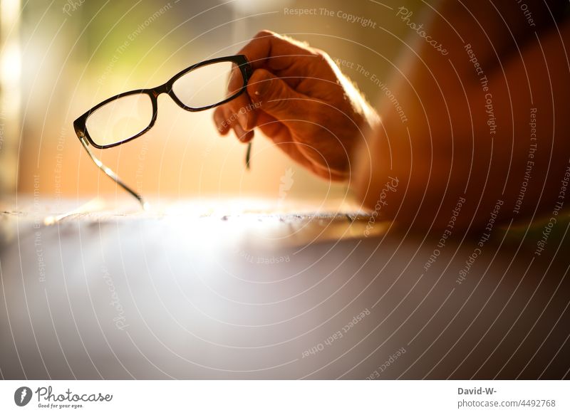 Mann hält eine Brille in der Hand nachdenklich Gedanken anonym Sehvermögen denken überlegen nachdenken festhalten Sonnenlicht Alltagsfotografie