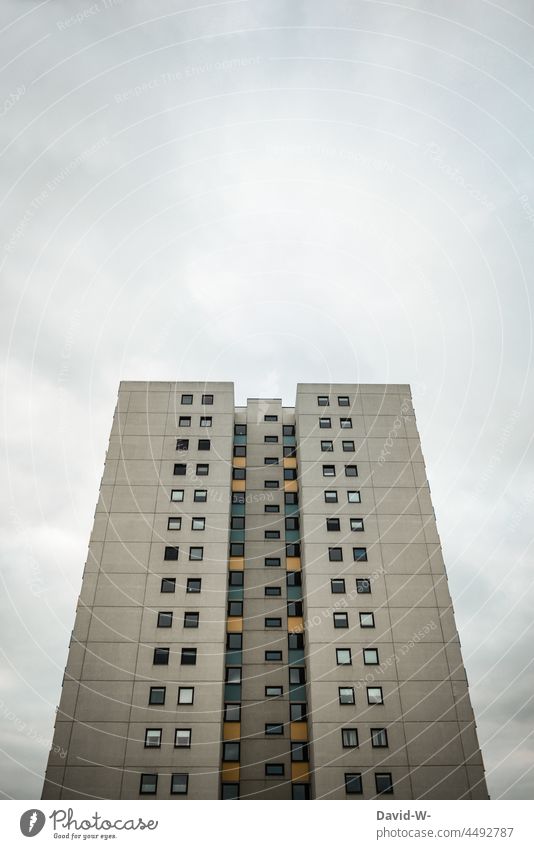 Hochhaus mit vielen Fenstern ragt in den Himmel ungemütlich hoch hässlich Betonklotz düster wohnen Hotel Gebäude unschön groß grau trist