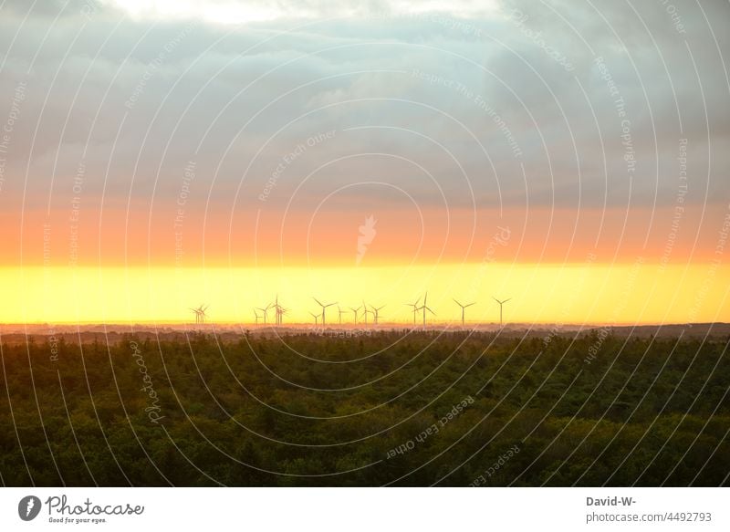 Windräder bei Sonnenuntergang zwischen Wald und Wolken windräder Klimaschutz Windkraftanlage Erneuerbare Energie Windenergie nachhaltig Umweltschutz