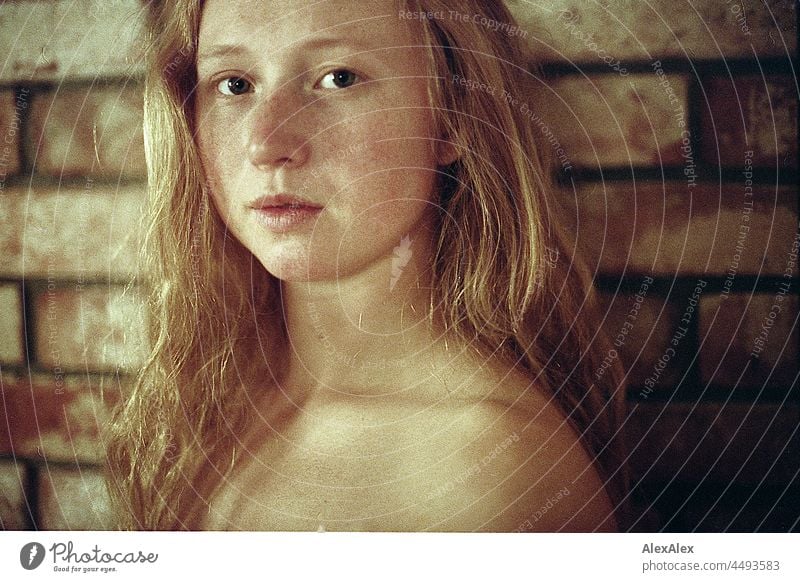 analoges Portrait einer jungen Frau mit Sommersprossen und roten Haaren, die vor einer Backsteinwand steht Porträt nah Nähe Ausstrahlung Ruhe kraftvoll hübsch