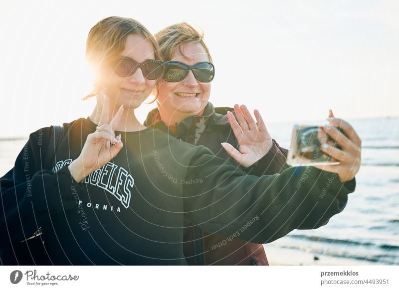 Frauen winken während eines Videogesprächs auf dem Smartphone während einer Reise im Sommerurlaub Anruf Telefon Talkrunde gestikulieren Gruß unter Foto Selfie