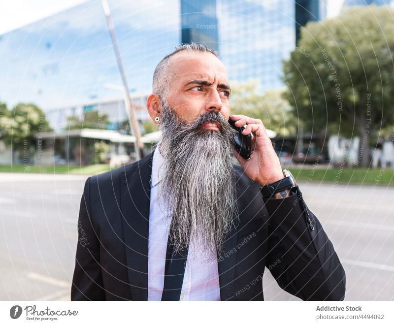 Seriöser Hipster im Anzug, der mit seinem Smartphone spricht Mann Stil formal Straße Großstadt trendy Telefonanruf diskutieren Gespräch Kommunizieren