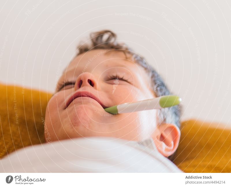Krankes Kind misst die Temperatur zu Hause messen kalt Grippe krank elektronisch Thermometer heimwärts Junge Fieber Infektion Krankheit Liege Symptom Virus
