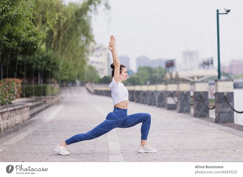 Porträt der glücklichen jungen kaukasischen Frau übt Yoga im Freien am frühen Morgen. Schönes Mädchen übt Asana im Park im Sommer Übung Gesundheit Wohlbefinden