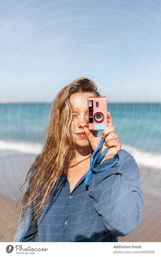 Frau fotografiert mit Kamera MEER Strand Fotoapparat Gerät Sand Sommer Wasser nass Ufer fotografieren Küste jung Apparatur Natur Gesicht machen Gedächtnis
