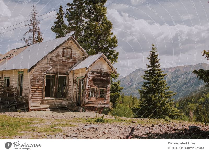 Altes verlassenes Haus inmitten der Berge, in einer Geisterstadt reisen Abenteuer Holzhaus Menschenleer Western Geisterhaus Wilder Westen Bäume