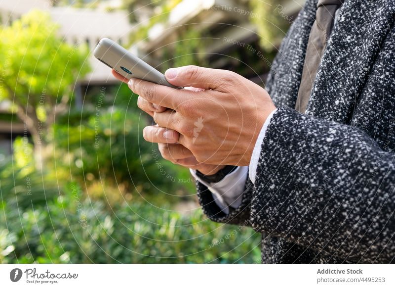 Anonymer Geschäftsmann spricht in der Stadt mit seinem Smartphone Mann Textnachrichten gut gekleidet freundlich Browsen unabhängig Großstadt benutzend Apparatur