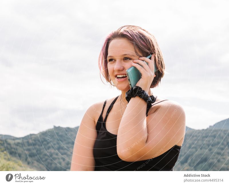 Junge Frau beim Telefonieren mit dem Smartphone in bergigem Gelände sprechen Telefonanruf online Natur Berge u. Gebirge Hochland Internet Zeitvertreib Freizeit