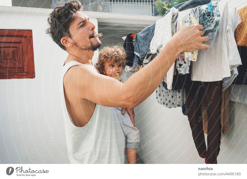 Junger Mann macht die Wäsche zu Hause Wäscherei heimwärts Kleidung Waschen Sauberkeit frisch Wäsche waschen backyarkd Familie Baby männlich modern Maskulinität