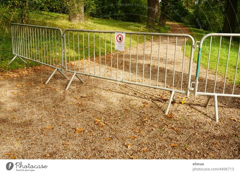 Absperrgitter und Schild signalisieren, dass der Parkweg nicht betreten werden darf / Gefahrenstelle / Warnhinweis Weg Gitter Baumbruch Sicherheitsmaßnahme