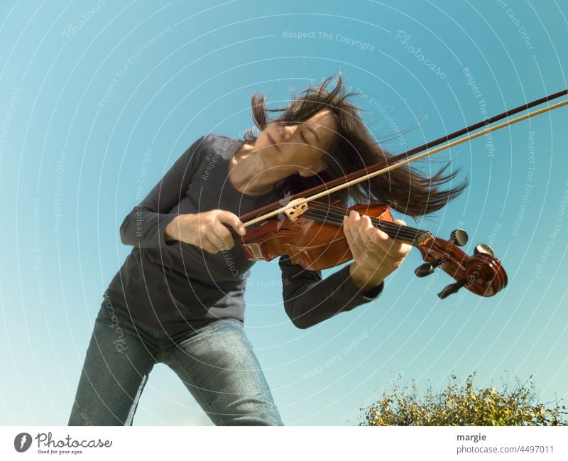 Eine Frau spielt unter blauem Himmel Geige Mensch feminin Farbfoto Junge Frau Porträt Spielen Erwachsene Musik Musikinstrument Freude Leidenschaft