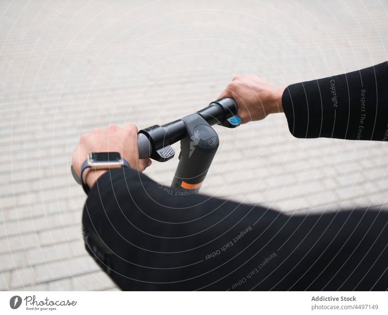 Crop stilvollen Mann Reiten E-Roller auf der Straße Mitfahrgelegenheit Tretroller trendy elektrisch e-Scooter Verkehr Großstadt Fahrzeug Stil Straßenbelag