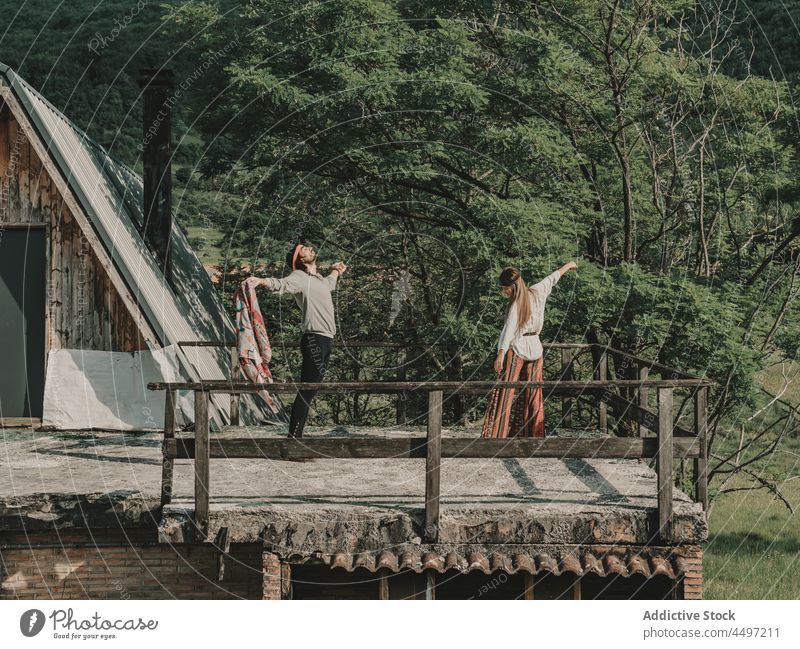 Hippie-Paar tanzt in der Nähe der Hütte Tanzen Bonden Natur Landschaft Freiheit Freizeit Kabine Zeitvertreib Boho Erholung Sommer Bohemien Struktur Harmonie