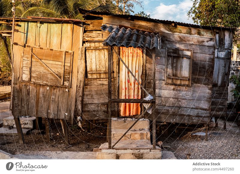 Älteres verlassenes Holzhaus vor grünen Bäumen Haus Dorf Landschaft hölzern Verlassen Armut gealtert Außenseite Fassade São Tomé und Príncipe Afrika Natur