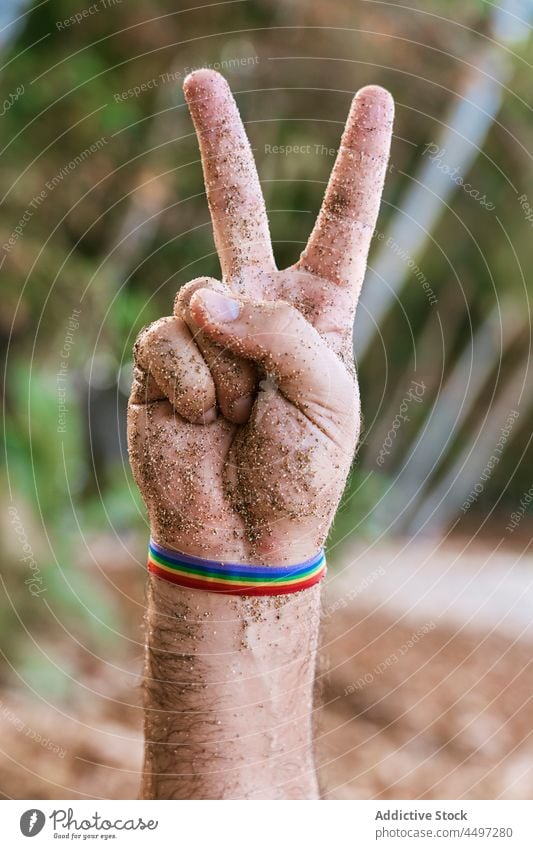 Mann mit Regenbogenband an der Hand zeigt Friedensgeste gestikulieren Armband Symbol lgbtq Toleranz zeigen männlich São Tomé und Príncipe Afrika Homosexualität