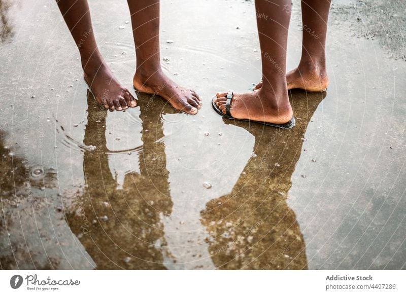 Schwarze barfuß Menschen stehen in Pfütze auf der Straße Barfuß nass Asphalt Wasser Bürgersteig Flip-Flop São Tomé und Príncipe Afrika Afrikanisch schwarz