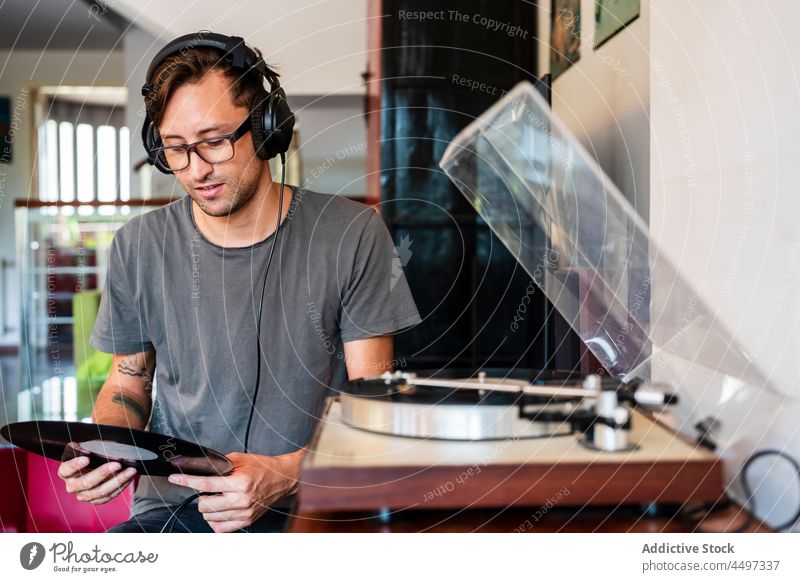 Mann mit Kopfhörern, der Musik von einem Player hört meloman zuhören Klang Spieler Melodie Aufzeichnen Plattenteller Brille Gesang Konzentration Nostalgie