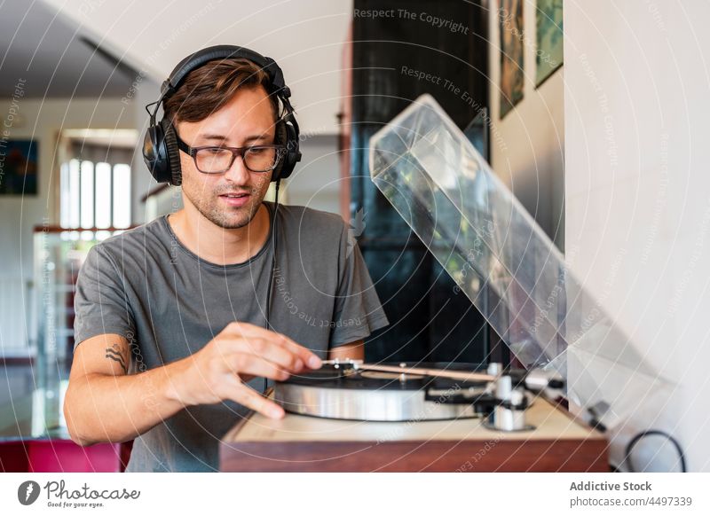 Mann mit Kopfhörern, der Musik von einem Player hört meloman zuhören Klang Spieler Melodie Aufzeichnen Plattenteller Brille Gesang Konzentration Nostalgie