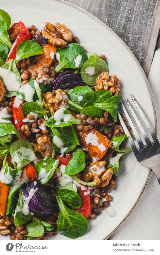 Leckerer Salat mit Gemüse und Basilikumblättern Salatbeilage Mahlzeit Lebensmittel Walnussholz Linse Küche dienen gesunde Ernährung Speise lecker organisch