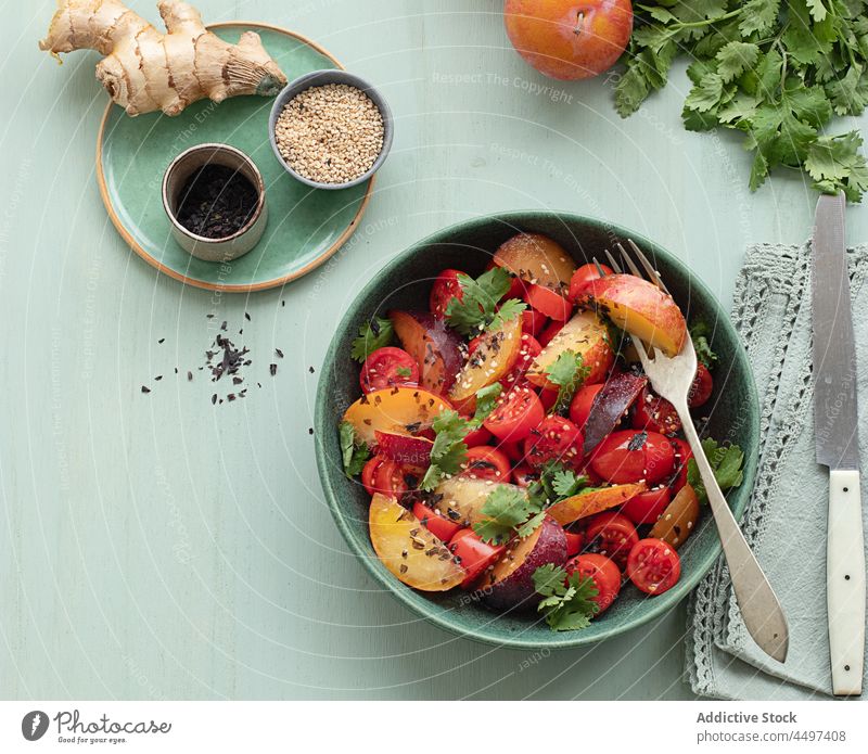 Tomatensalat mit Obst auf dem Tisch Salatbeilage Teller Vegetarier farbenfroh Zutaten Frucht Pflaume balsamisch Sommergerichte Mahlzeit Mittagessen Speise