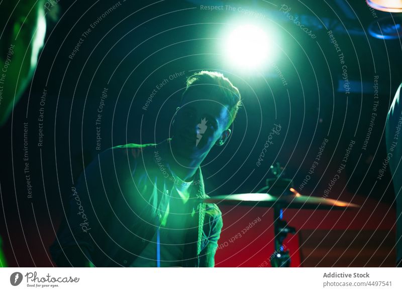 Männer spielen Instrumente in einem Neon-Club Band ausführen Musik neonfarbig Trommel Musiker ernst männlich jung professionell Nachtclub Klang Gesang Lifestyle