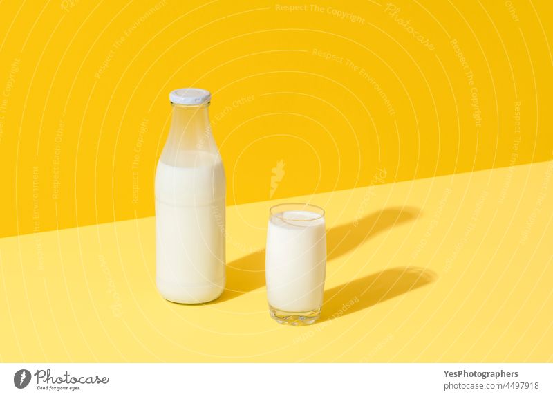 Milch in Glas und Flasche, minimalistisch auf gelbem Hintergrund abstrakt Getränk Biografie Frühstück hell Kalzium Sauberkeit Farbe Container Textfreiraum Kuh