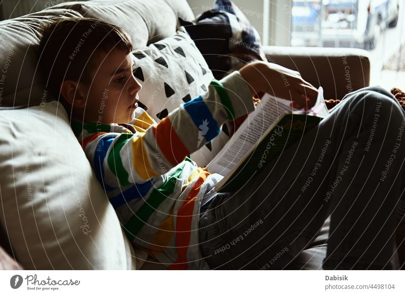 Kind Junge liest Buch auf dem Sofa zu Hause lesen sich[Akk] entspannen lernen Bildung Lifestyle Literatur ruhen Schule Schuljunge heimwärts im Innenbereich
