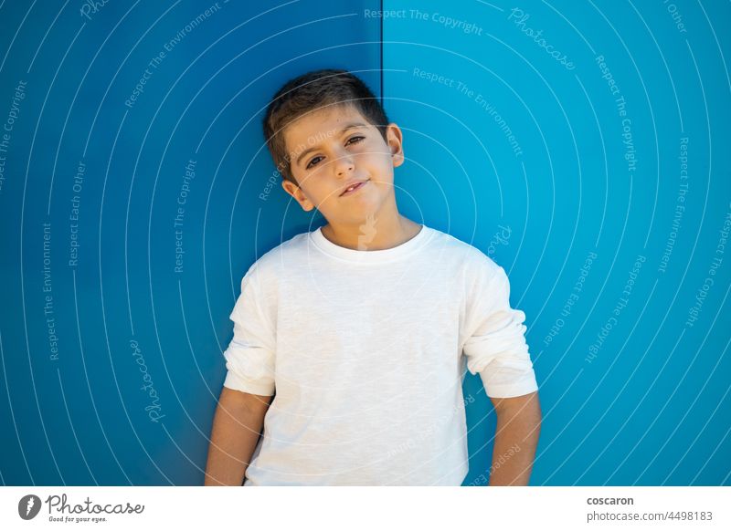 Hübscher Junge mit weißem T-Shirt auf blauem, schwarzem Grund attraktiv Hintergrund schön blond sorgenfrei Kaukasier heiter Kind Kindheit farbenfroh niedlich
