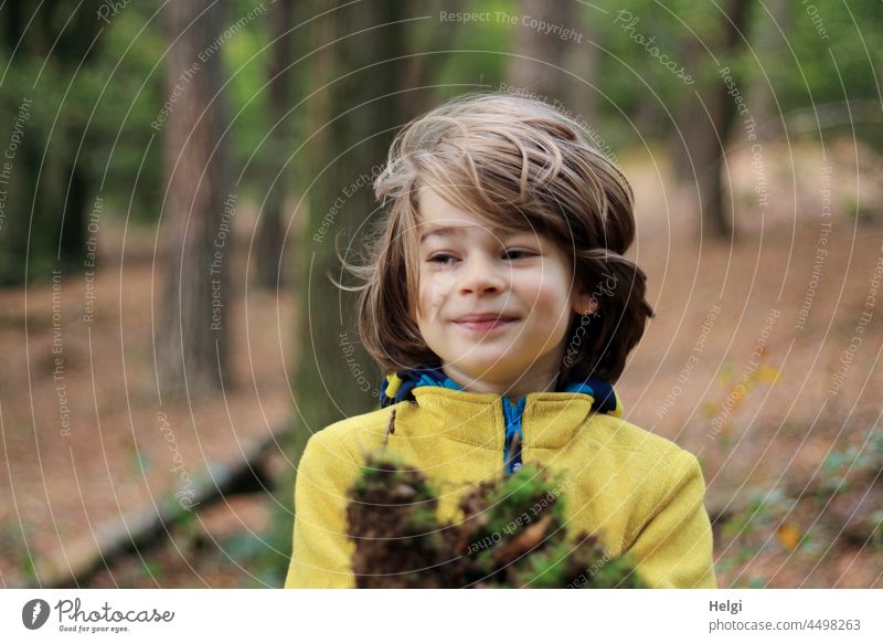 Kinderfreuden - Junge spielt im Wald mit Naturmaterialien Mensch draußen spielen Freude Spaß Porträt Moos Spiel Kindheit Außenaufnahme 3-8 Jahre Fröhlichkeit