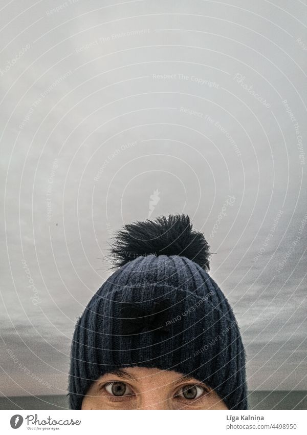 blaue Wintermütze gegen grauen Himmel Hut Frau Farbfoto Mensch Kopfbedeckung Bekleidung Wollmütze kalt Wärme Mode Erwachsene Jahreszeiten Außenaufnahme feminin