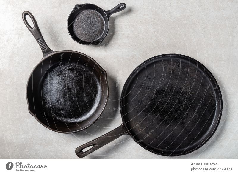 Gusseiserne Pfannen oder Bratpfannen auf grauem Hintergrund Eisenguss braten Gesundheit Lebensmittel leer Top dunkel kulinarisch Essen zubereiten Ansicht Küche