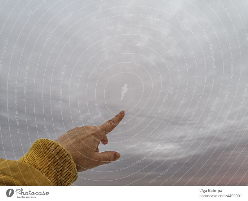 Finger zeigt auf den grauen Himmel Zeigen jung Frau Menschen Lifestyle Person Erwachsener im Freien Natur kalt Skyline gelb