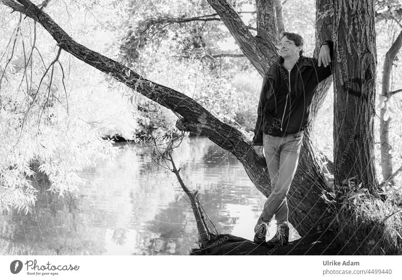 UT Teufelsmoor l Aussicht genießen - Mann lehnt entspannt an einem Baum am Flussufer Erwachsener Mann mittleren Alters Mensch Ein Mann allein Natur schwarzweiß