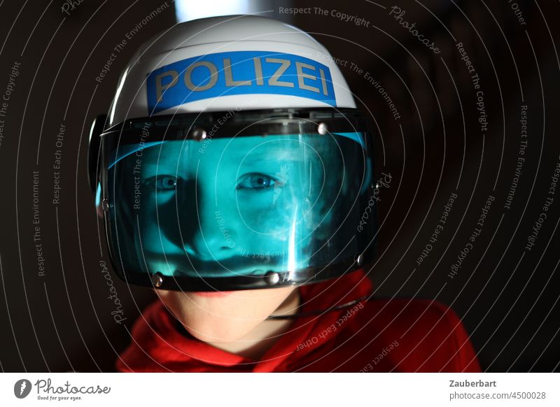 Junge spielt mit Polizeihelme und blauem Visier erschrecken Spiel Kinder Kindheit Spaß spielen Freizeit rot Freude verkleiden Verkleidung